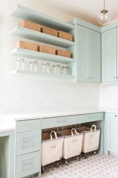 a kitchen with blue cabinets and baskets on the shelf above it's countertop