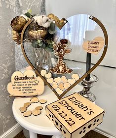 a heart shaped display with wooden signs and decorations on a table in front of a wall