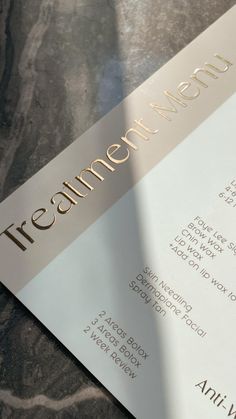 a close up of a menu on a table with a black and white marble background