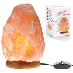 an orange himalayan salt lamp sitting on top of a wooden stand next to a box