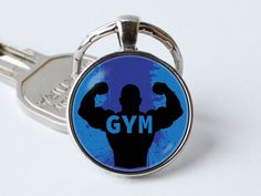 a keychain with a man's body and the word gym printed on it