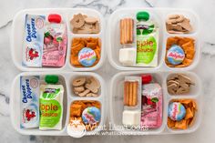 four plastic containers filled with food on top of a marble countertop next to a bottle of yogurt