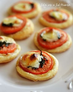 small appetizers with tomatoes and cheese are on a white plate, ready to be eaten