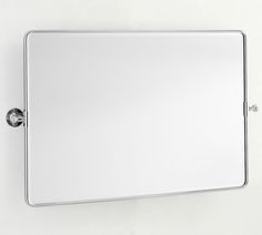 a bathroom mirror mounted to the wall with a chrome frame and knobs on it