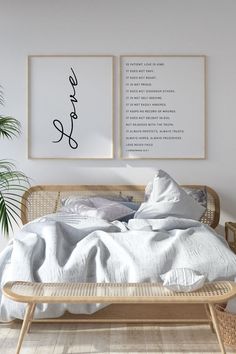 two framed pictures on the wall above a bed in a room with wooden flooring and wicker furniture