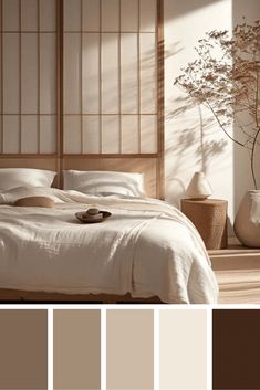 a bed with white sheets and pillows in a room next to a vase filled with flowers