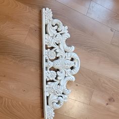 an ornate white wooden shelf on the floor