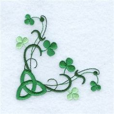 an embroidered design with shamrocks and leaves on the side of a white cloth background