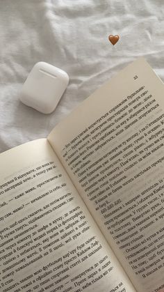 an open book sitting on top of a bed next to a computer mouse and keyboard