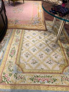 an area rug with various colors and designs on it in a room filled with furniture