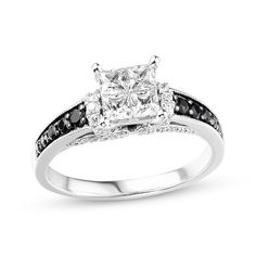 a princess cut diamond ring with black and white diamonds on the band, set in 18k white gold