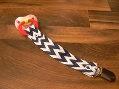 a black and white chevroned leash with a red handle on a wooden floor