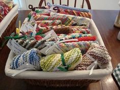 a basket filled with lots of colorful crocheted items on top of a wooden table