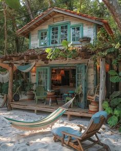 a hammock sitting in front of a house on the beach