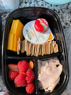 a plastic container filled with fruit and crackers