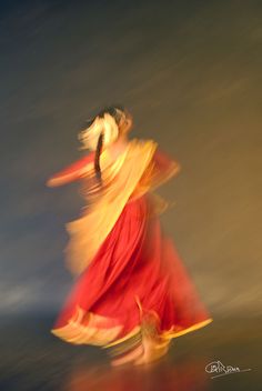 a woman in a red and yellow dress is dancing