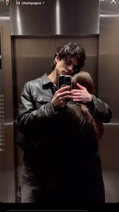 a man taking a selfie with his cell phone while standing in front of an elevator