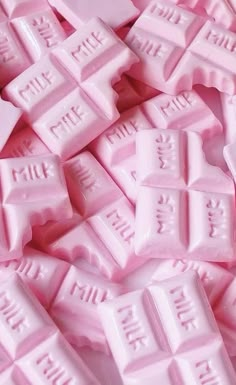 a pile of pink candy bars with white letters on them