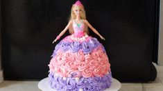 a barbie doll cake with pink and purple frosting