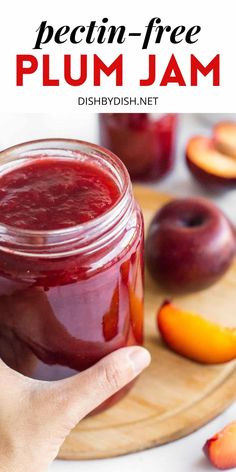 a hand holding a jar of plum jam with peaches in the background and text overlay that reads, pectin - free plum jam