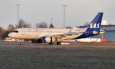 a large passenger jet sitting on top of an airport tarmac with buildings in the background