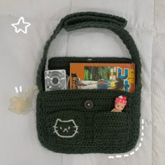 a crocheted purse with a camera and magazine in it