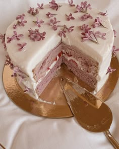 a cake with white frosting and pink flowers on it