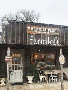 an old fashioned store front with chairs and tables outside