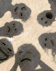 several people standing in the sand with their shadows on them