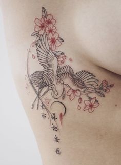 a woman's breast with a bird and flowers tattoo on her left side ribcage