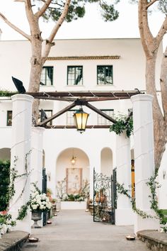 an outdoor wedding venue with white flowers and greenery at the entrance to the building