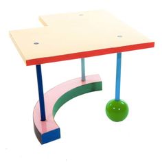 a small table with a green ball on it's legs and a pink base