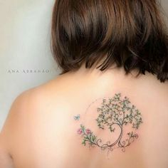 a woman's back with a tree tattoo on it