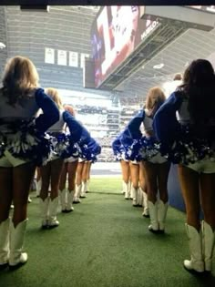 the cheerleaders are lined up in their blue and white outfits at the game