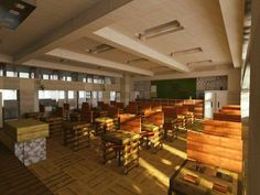 a large room filled with lots of wooden tables and chairs