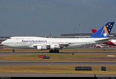 an airplane that is sitting on the runway at an airport with other planes in the background