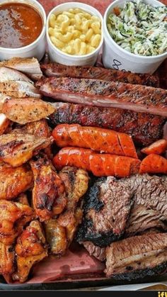 there are many different types of meats and sides on this tray with macaroni salad