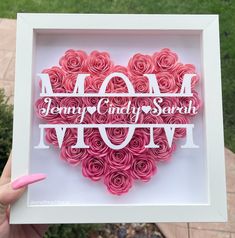 a heart made out of paper with the words mom and love spelled on it in white frame