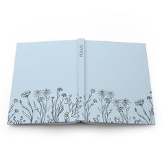 an open book with flowers and plants on the front cover, in light blue color