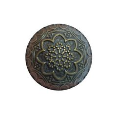 a metal button with an ornate design on it