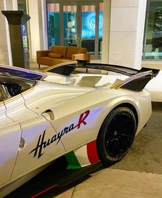 a white sports car parked in front of a building