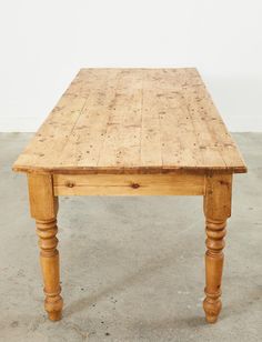 an old wooden table sitting on concrete floor