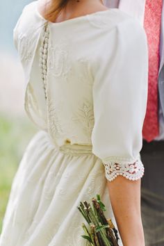 a woman in a white dress holding a bouquet of flowers