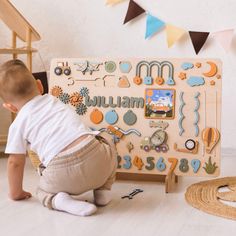 a baby is playing with a wooden board that has numbers and magnets on it