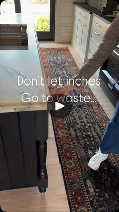 a person standing in front of a stove top oven next to a rug on the floor