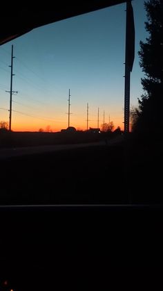 the sun is setting behind some power lines