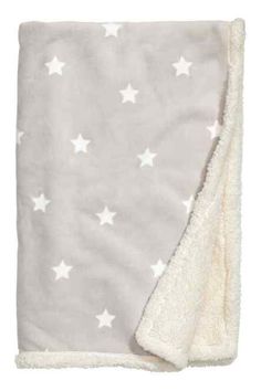 a blanket with white stars on it and a light gray back ground that is folded in half