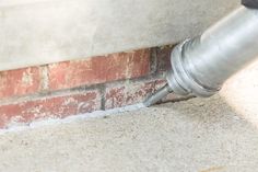 a metal pipe sticking out of the side of a brick wall