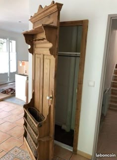 an old wooden armoire sitting in the middle of a room with tile flooring