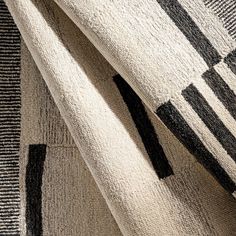 two black and white rugs on top of each other, one with an abstract design